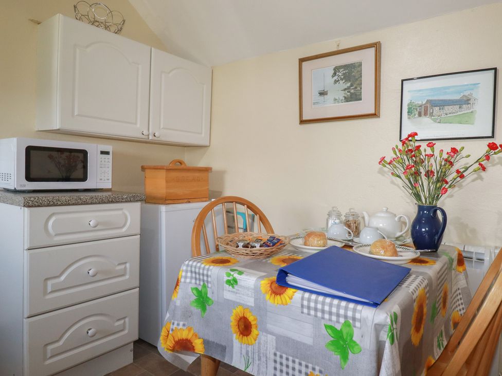 A kitchen with a dining table and a microwave at Moorland Retreat in Bodmin
