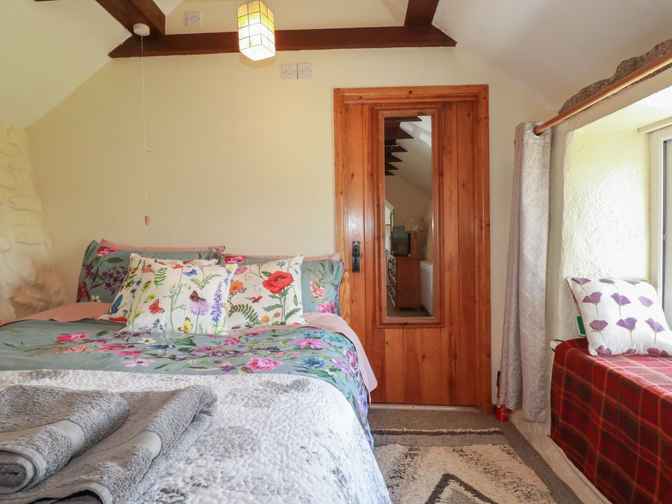 A bedroom with a bed and window seat at Moorland Retreat in Bodmin