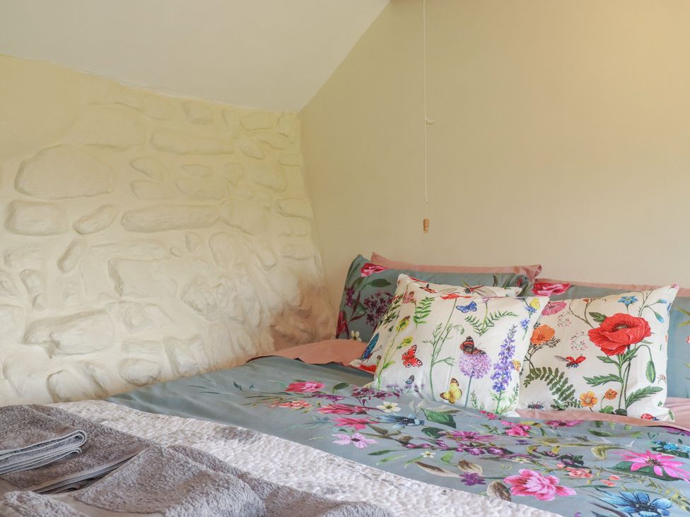 A bedroom with a bed and patterned pillows at Moorland Retreat in Bodmin