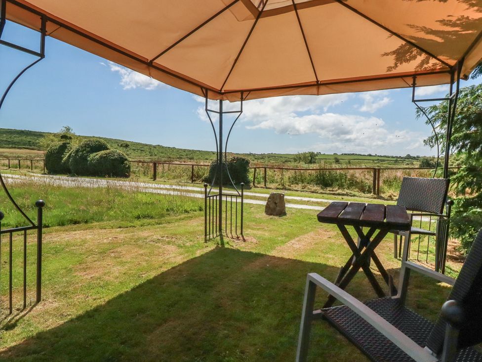 An outdoor seating area with a table and chairs at Moorland Retreat in Bodmin