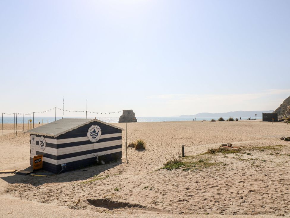 A beach hut on sand with ocean and sky at Moorland Retreat St Breward