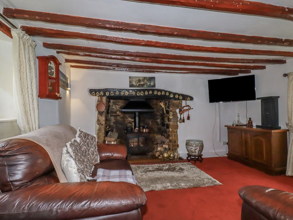 A living room with a fireplace and television at Rose Cottage in Launceston