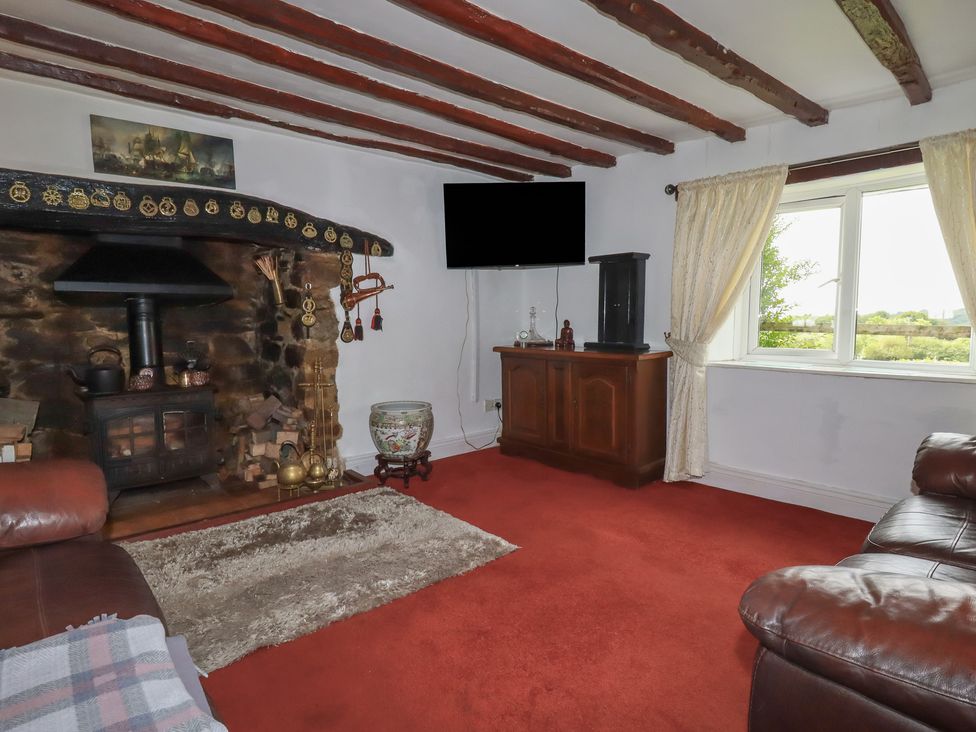 A living room with a fireplace and television at Rose Cottage in Launceston