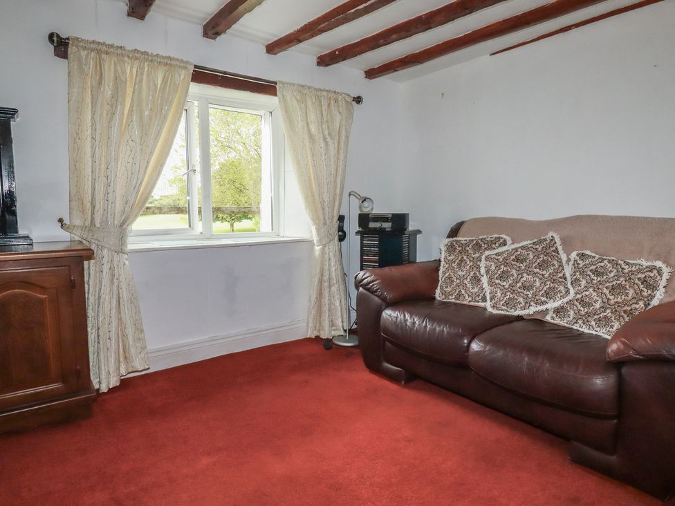 A living room with a sofa and curtains at Rose Cottage in Launceston