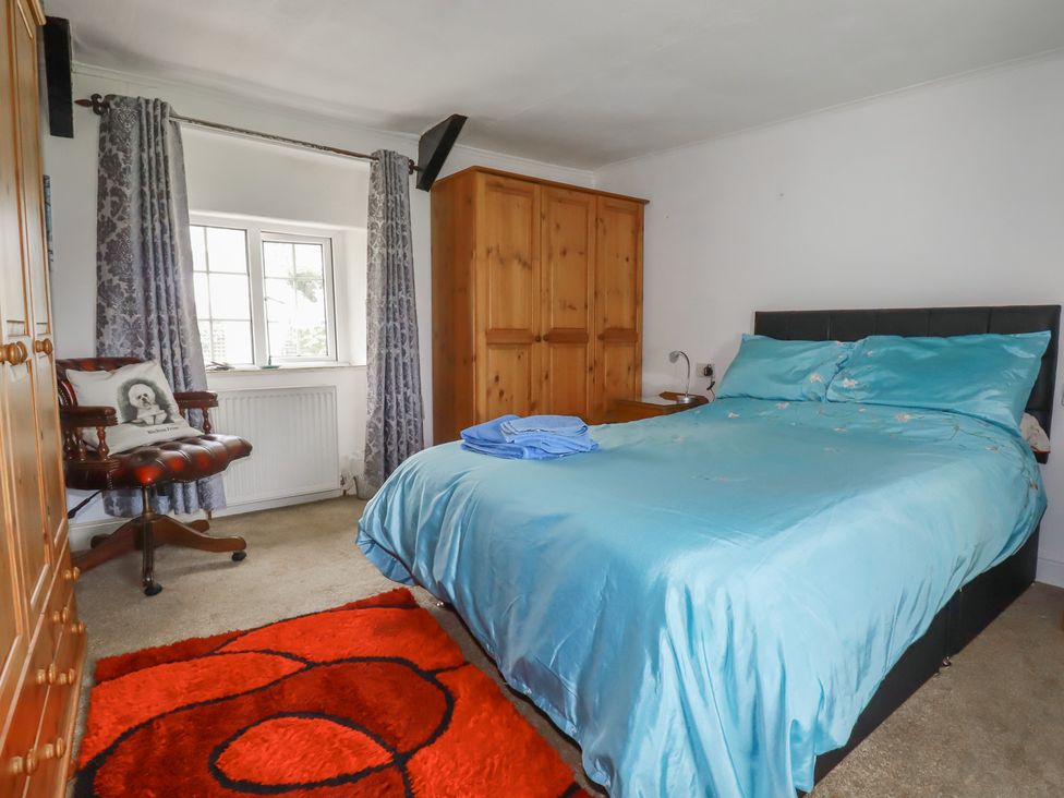 A bedroom with a bed and wardrobe at Rose Cottage in Launceston
