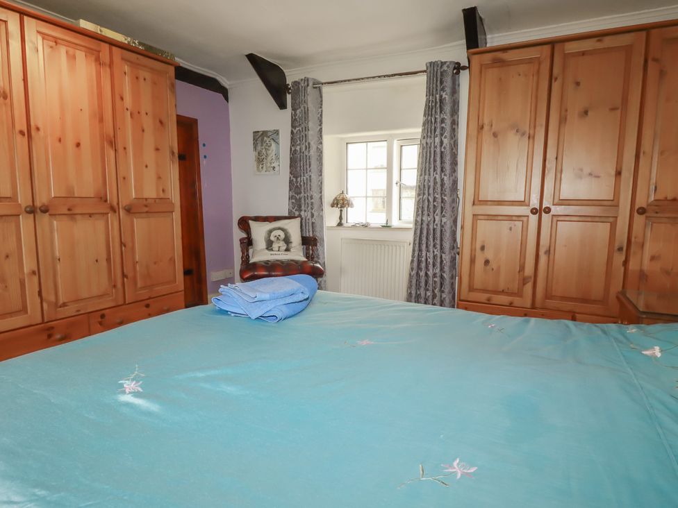 A bedroom with a bed and wardrobe at Rose Cottage in Launceston