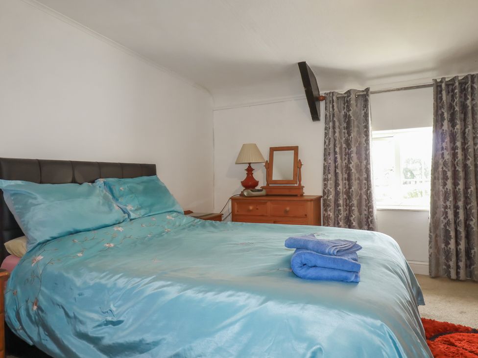 A bedroom with a bed and dressing table at Rose Cottage Launceston