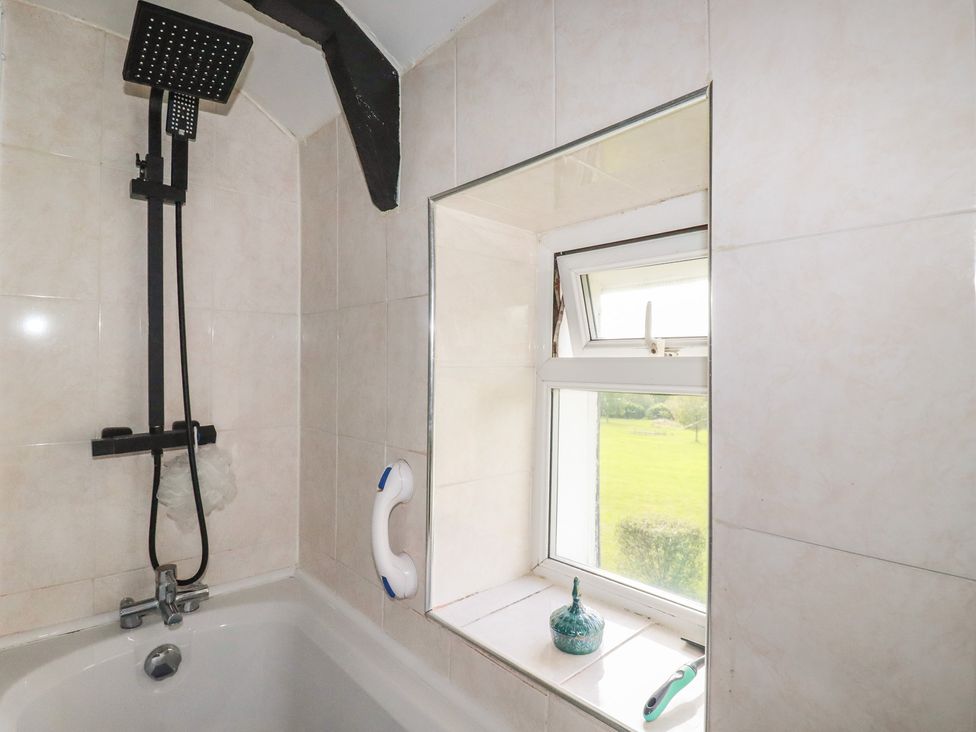 A bathroom with bathtub and shower head at Rose Cottage in Launceston