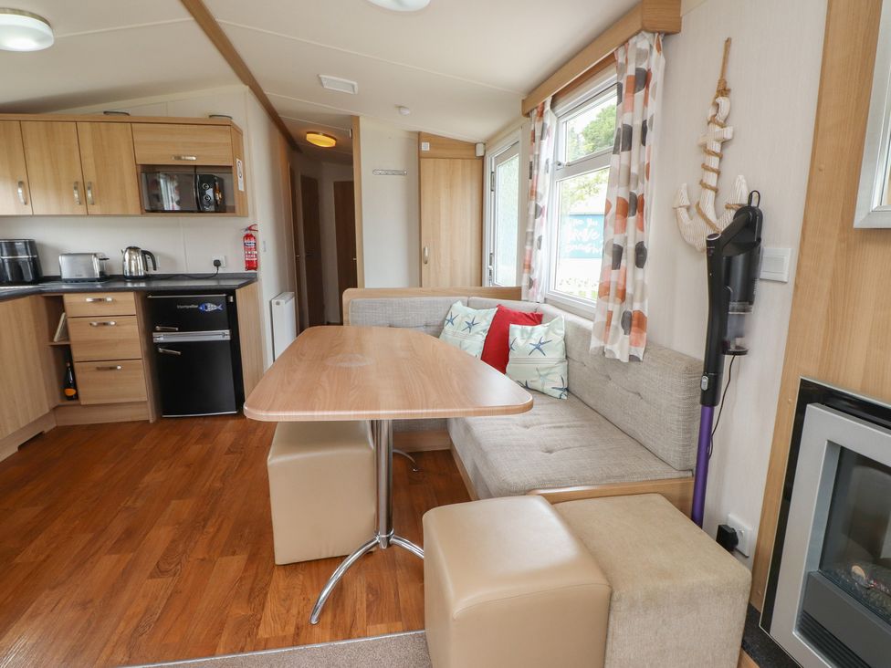 A kitchen with a dining area at 10 Cambrian Park in Pwllheli