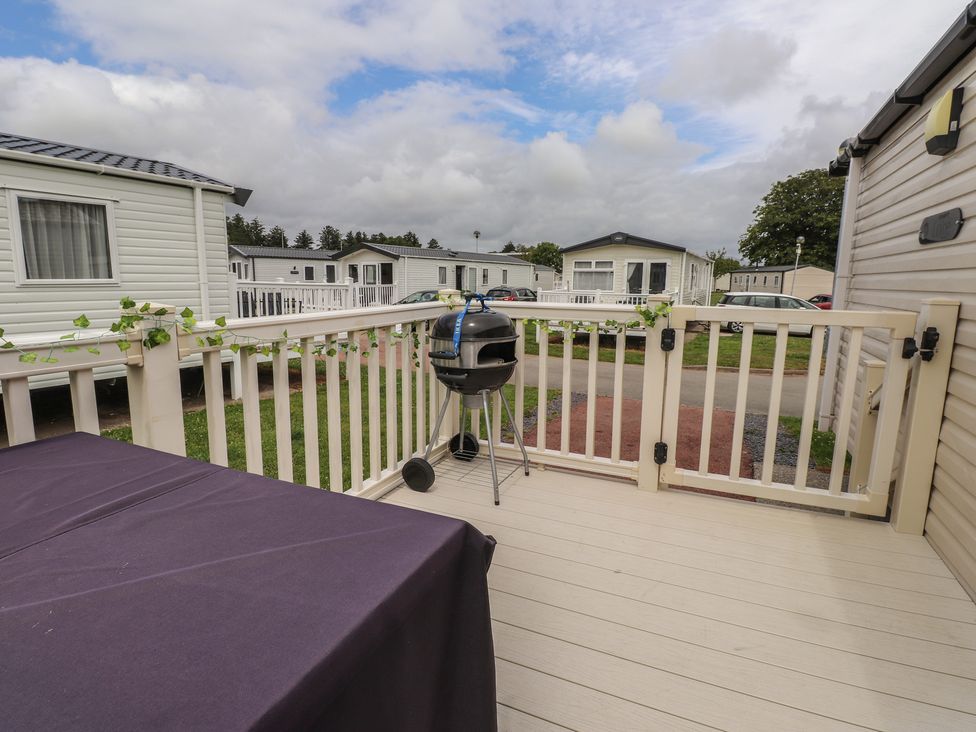 An outdoor area with a grill and table at 10 Cambrian Park in Pwllheli