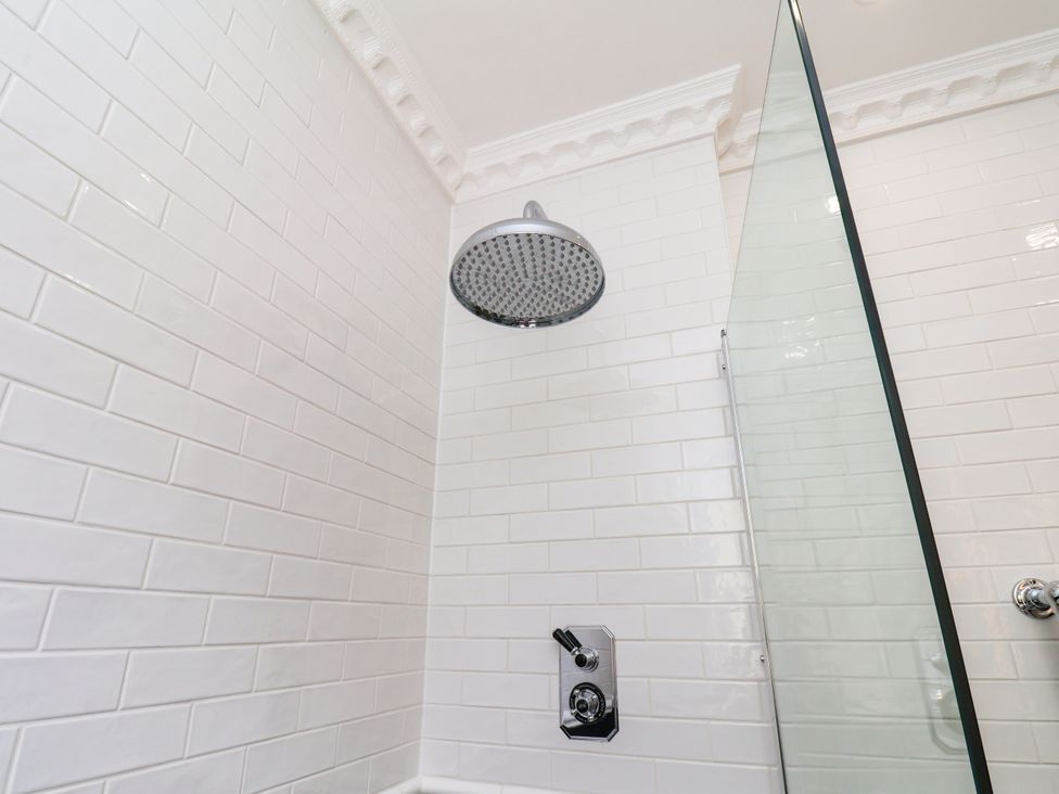 A shower with a showerhead and glass door at Sea View Apartment in Whitby