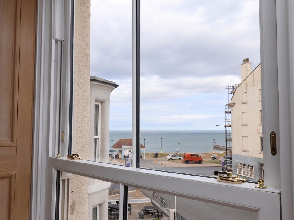 A view from a window looking at the sea and surrounding buildings at Sea View Apartment in Whitby