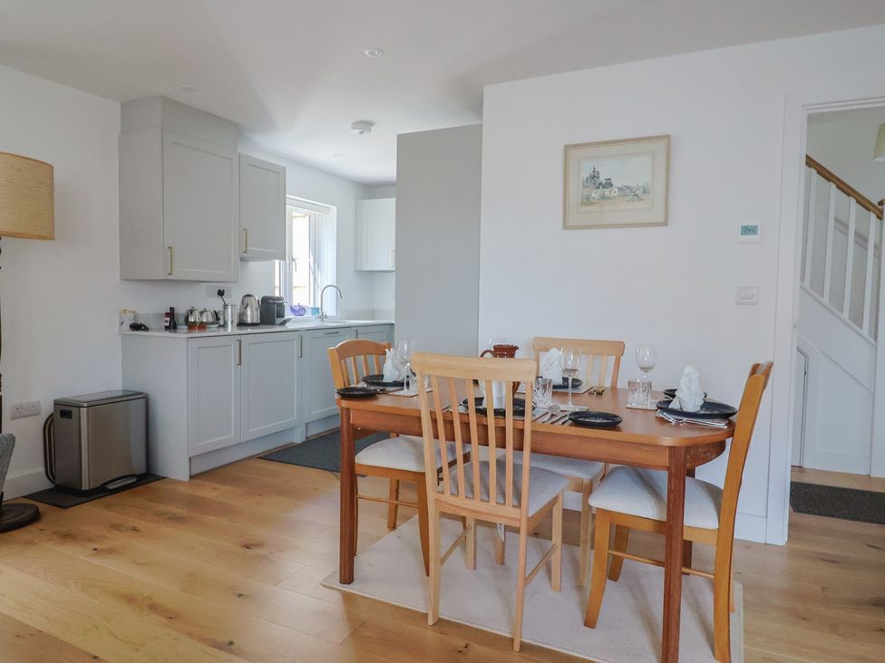 A dining room with a table and chairs at L'Ancresse Cottage in Lyme Regis
