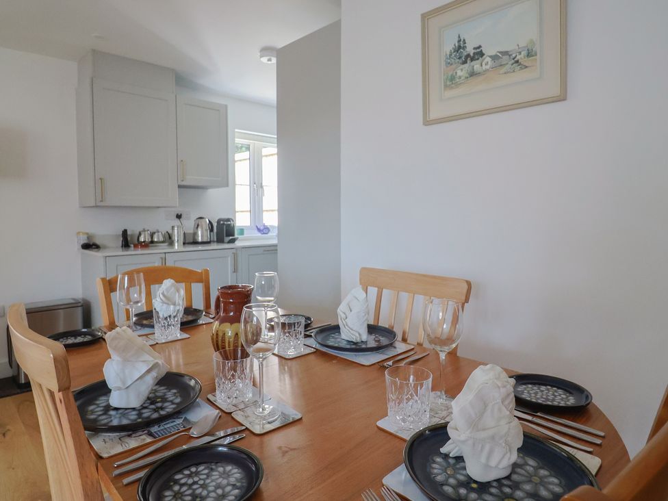 A dining room with a table set for a meal at L'Ancresse Cottage in Lyme Regis