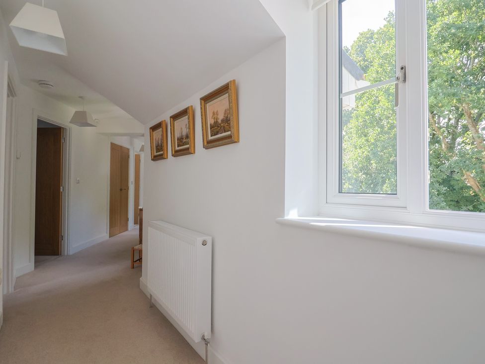 A hallway with a window and pictures on the wall at L'Ancresse Cottage in Lyme Regis