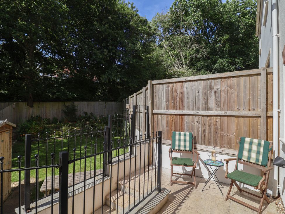 A garden area with chairs and a table at L'Ancresse Cottage in Lyme Regis