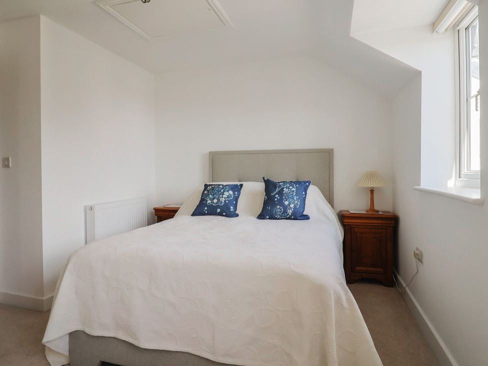 A bedroom with a bed and bedside table at L'Ancresse Cottage in Lyme Regis