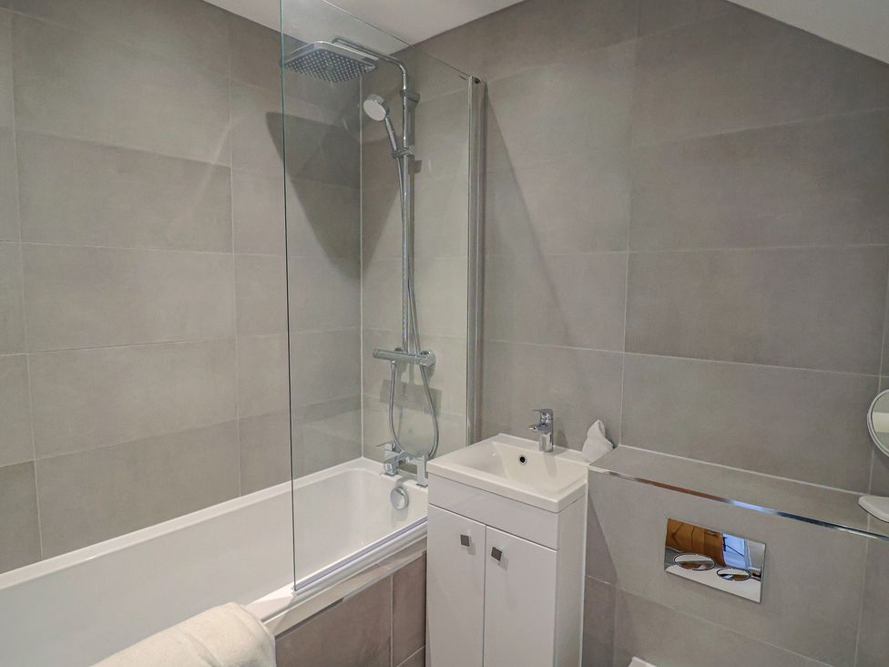 A bathroom with a bathtub and shower at L'Ancresse Cottage in Lyme Regis