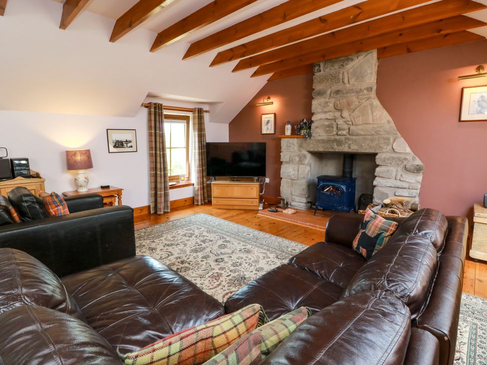 A living room with a sofa and television at Buchanan’s Bothy in Glencarse