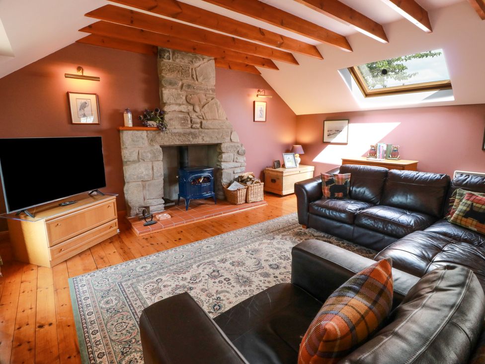 A living room with a sofa and television at Buchanan’s Bothy in Glencarse