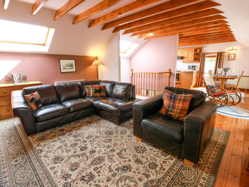 A living room with sofa and armchair at Buchanan’s Bothy in Glencarse