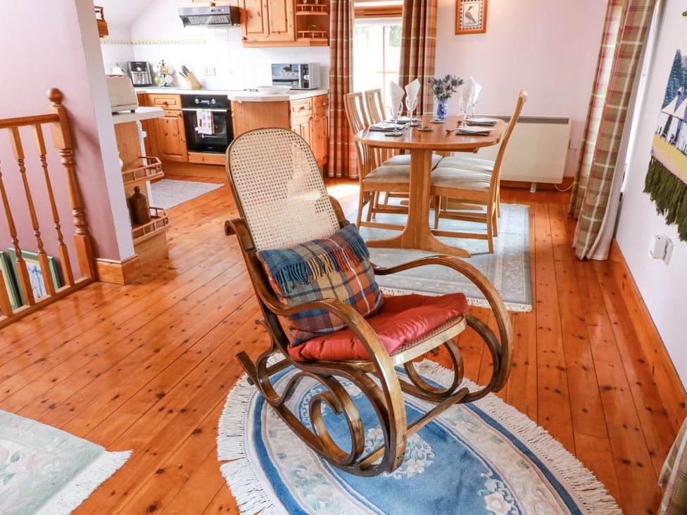 A living room with a rocking chair and dining table at Buchanan’s Bothy in Glencarse
