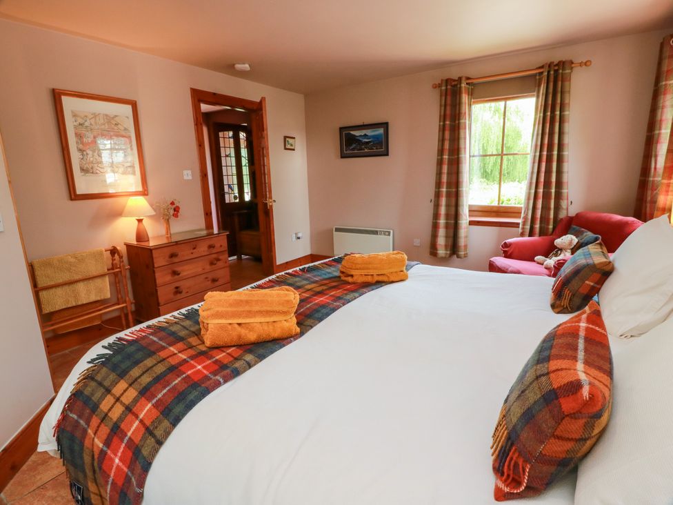 A bedroom with a bed and drawers at Buchanan’s Bothy, Glencarse