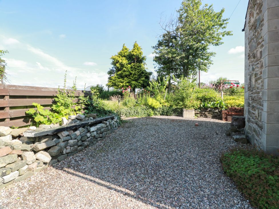 A garden area with gravel path and stone walls at Buchanan’s Bothy Glencarse