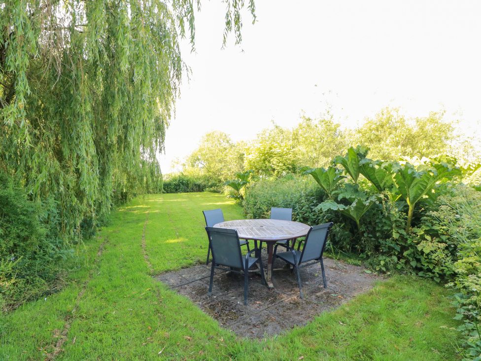 A garden with a table and chairs at Buchanan’s Bothy in Glencarse