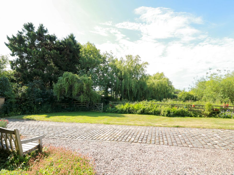A garden area with trees and a bench at Buchanan’s Bothy, Glencarse