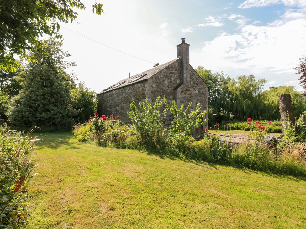 A garden with grass and flowers at Buchanan’s Bothy Glencarse