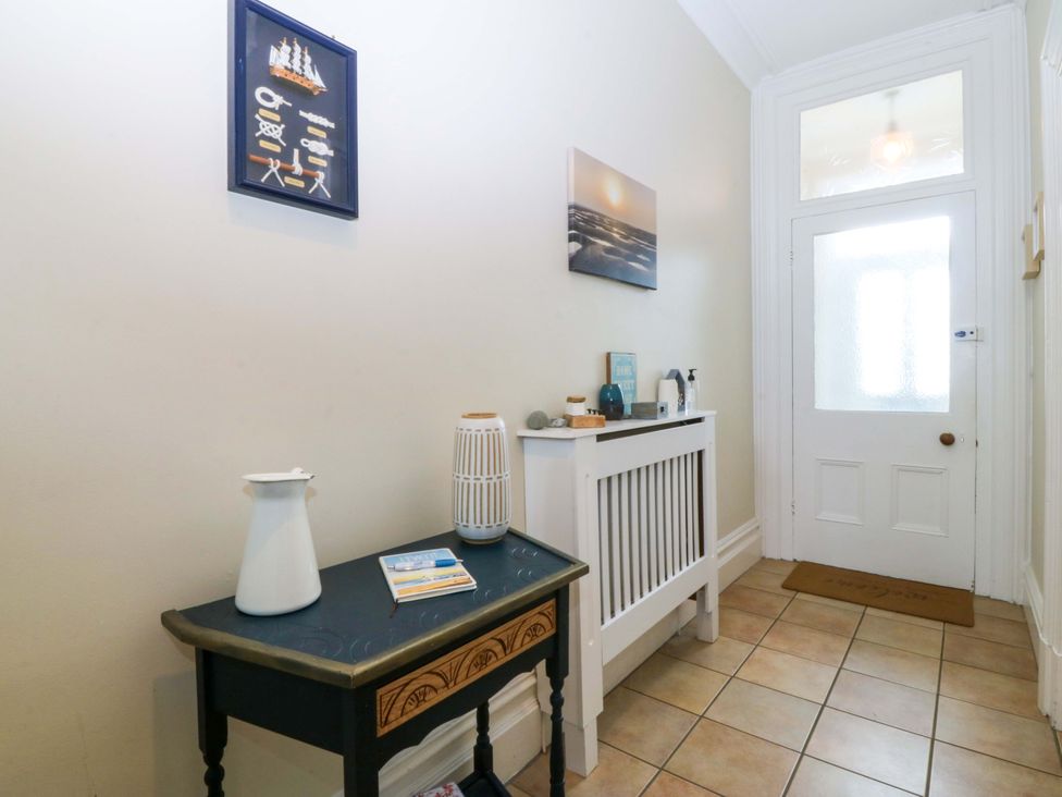 A hallway with a table and door at Jack's House in Tywyn