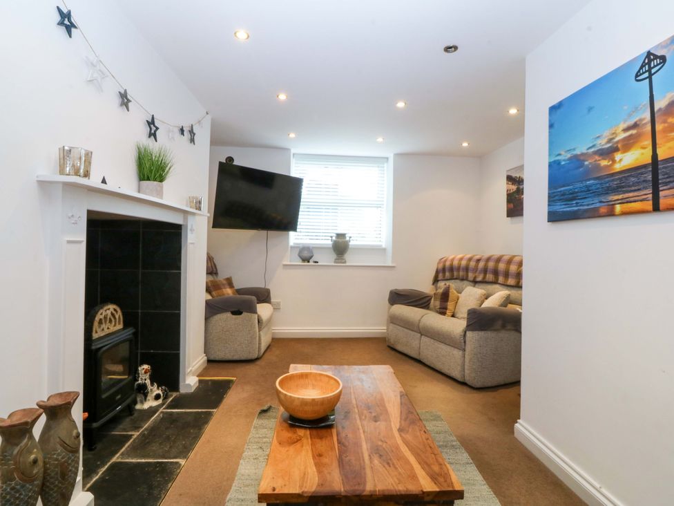 A living room with a sofa, coffee table, and a tv at Jack's House in Tywyn