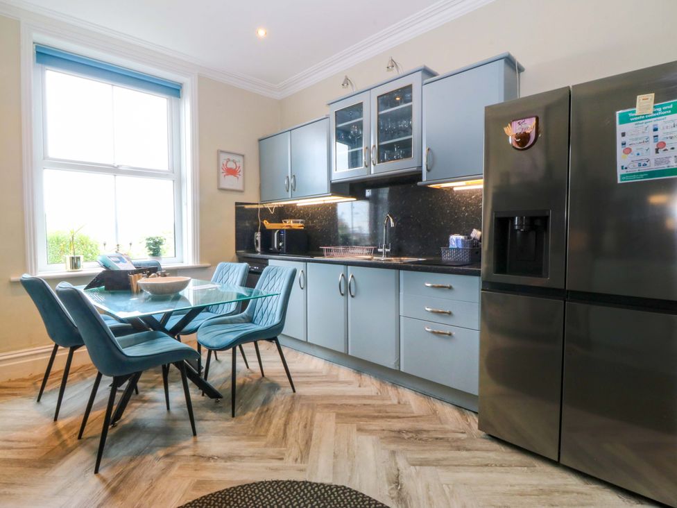 A kitchen with a dining table and chairs at Jack's House Tywyn