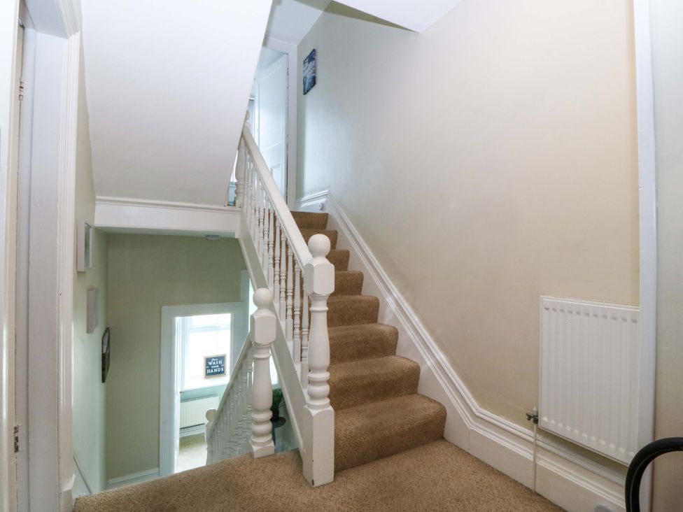 A hallway with stairs and a handrail at Jack's House in Tywyn