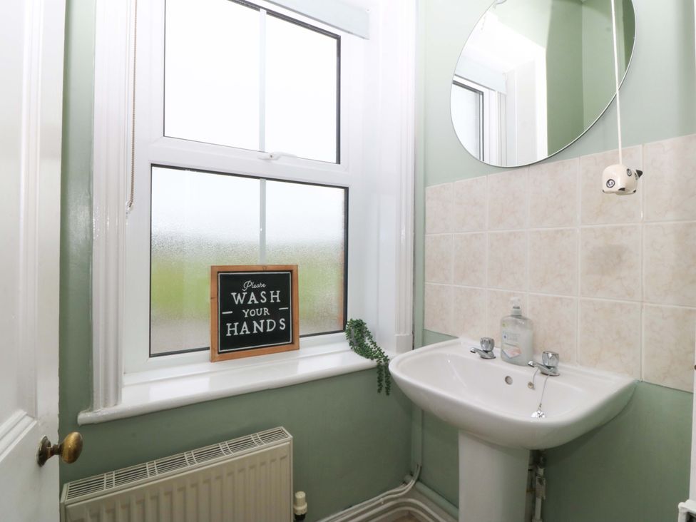 A bathroom with a sink and mirror at Jack's House Tywyn