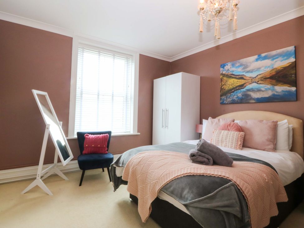 A bedroom with a bed and wardrobe at Jack's House in Tywyn