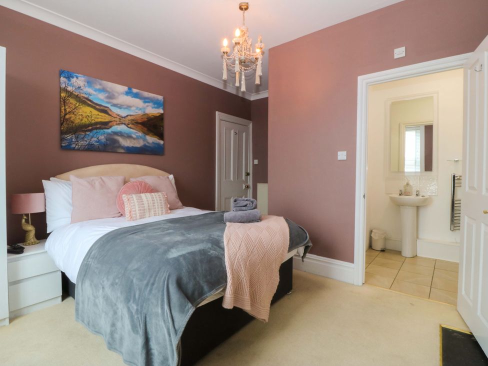 A bedroom with a bed and sink at Jack's House in Tywyn