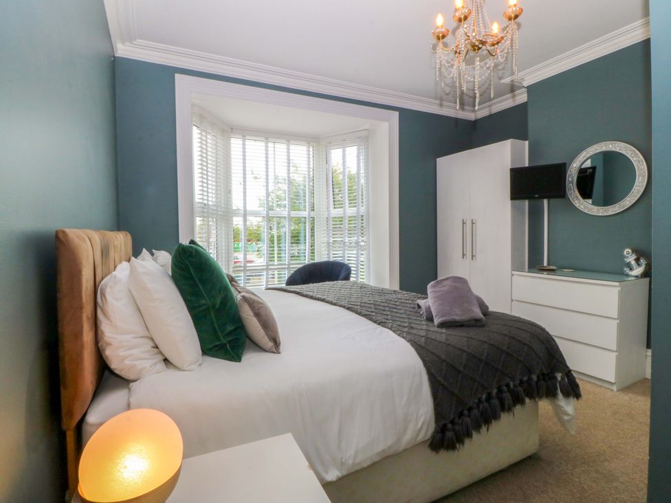 A bedroom with a bed and dresser at Jack's House in Tywyn