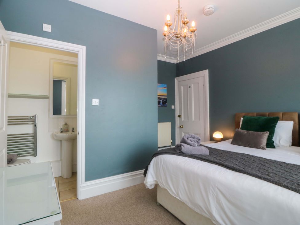A bedroom with a bed and a mirror at Jack's House Tywyn