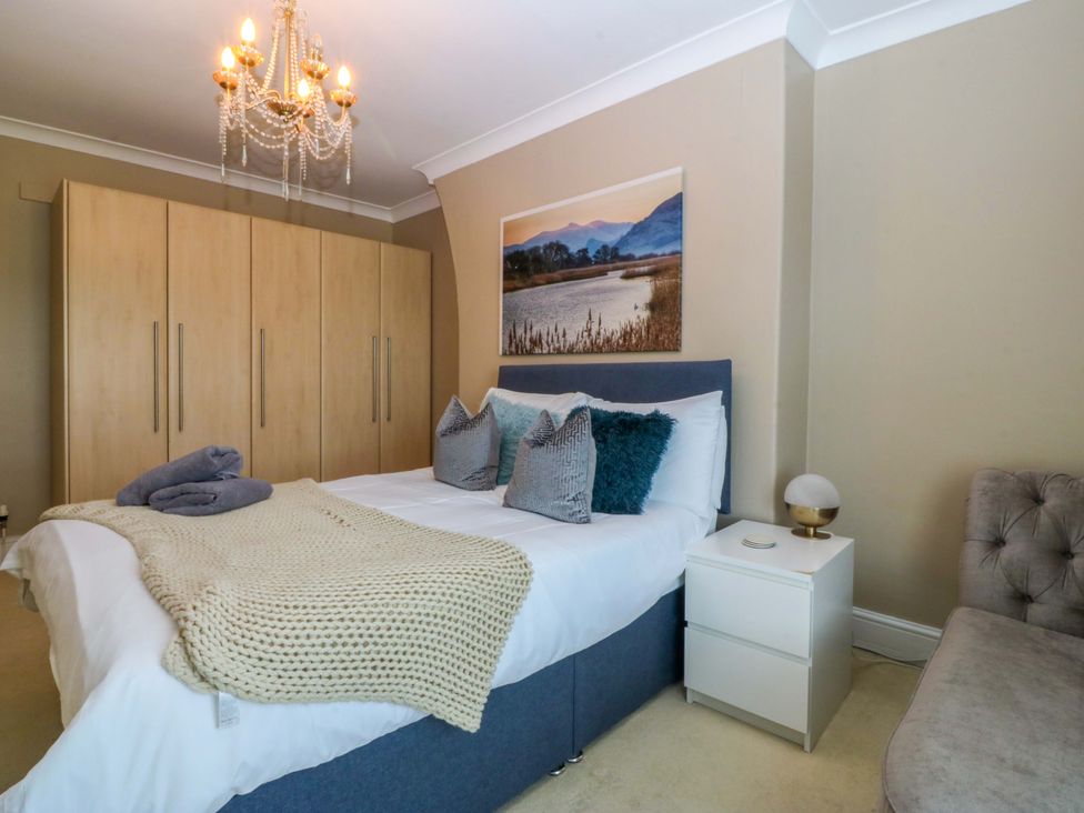 A bedroom with a bed and wardrobe at Jack's House in Tywyn