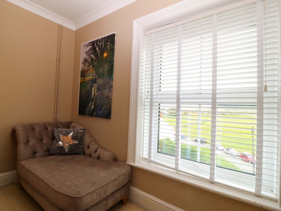 A living room with an armchair and a window at Jack's House in Tywyn