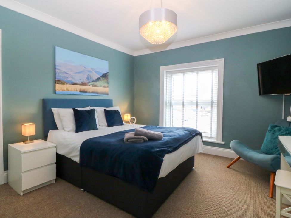 A bedroom with a bed and a window at Jack's House in Tywyn