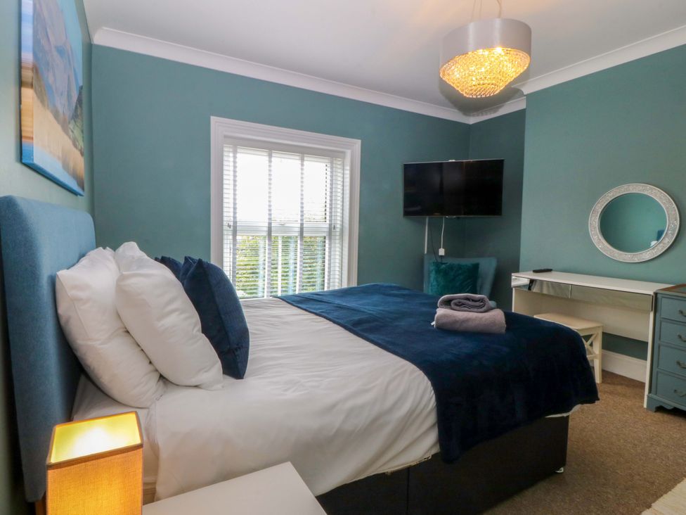 A bedroom with a bed and television at Jack's House in Tywyn