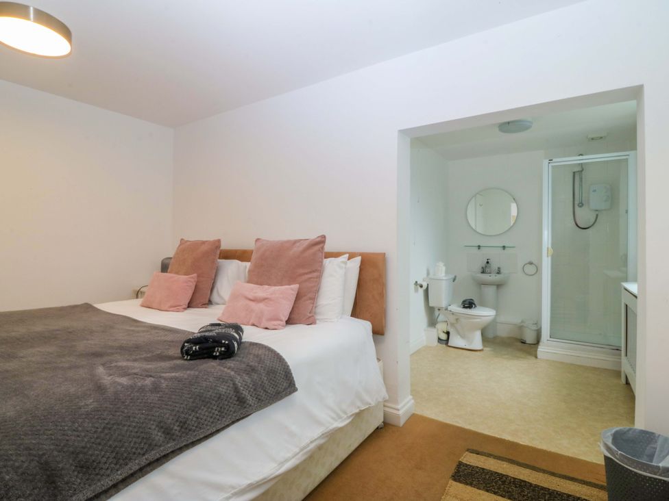 A bedroom with a bed and an attached bathroom at Jack's House in Tywyn