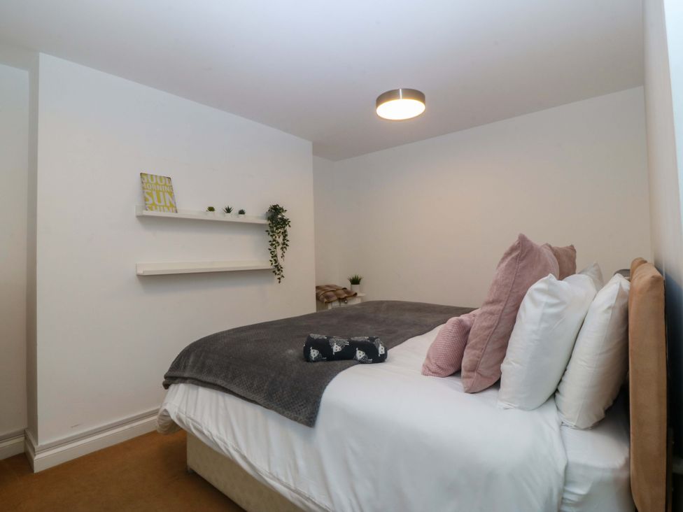 A bedroom with a bed and shelf at Jack's House in Tywyn
