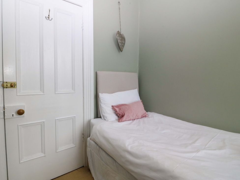 A bedroom with a bed and a door at Jack's House Tywyn