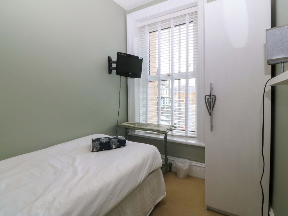 A bedroom with a bed and television at Jack's House Tywyn