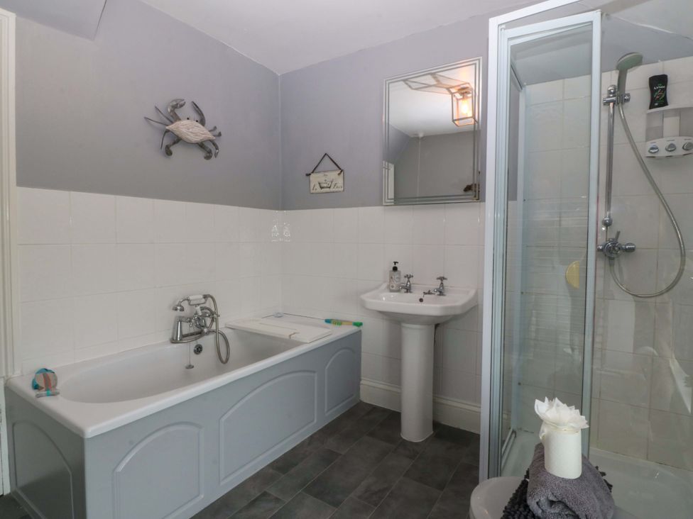 A bathroom with a shower and bathtub at Jack's House in Tywyn