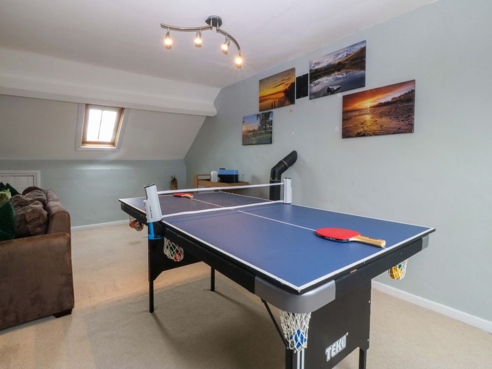 A game room with a table tennis table and a sofa at Jack's House in Tywyn